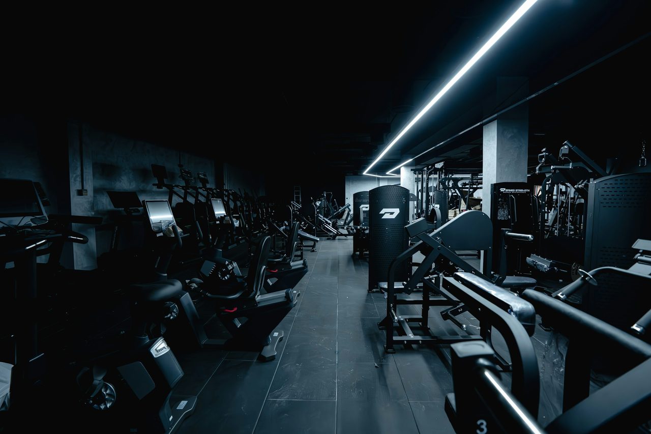 Commercial gym floor with cardio and strength equipment.