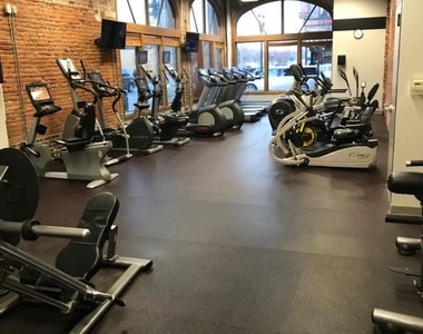 Cardio machines lined up along the gym floor.